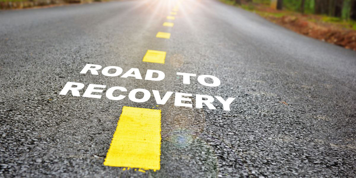 Text road to recovery painted on roadway