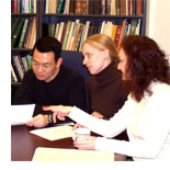 Image of 3 students sitting around table for meeting