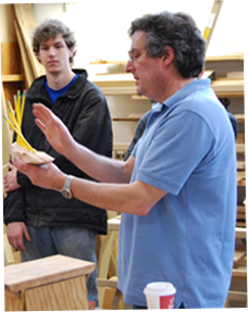 Image of 2 men in classroom with a handful of pencils