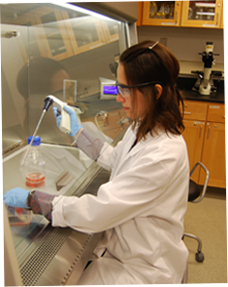 Image of female student with lab coat working in lab