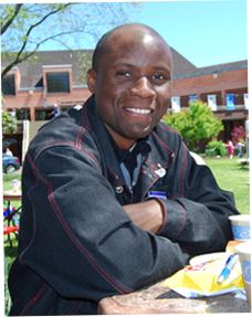 Image of male student sitting at picnic table on campus