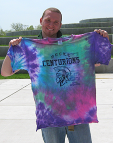 Image of male holding tie dyed shirt up