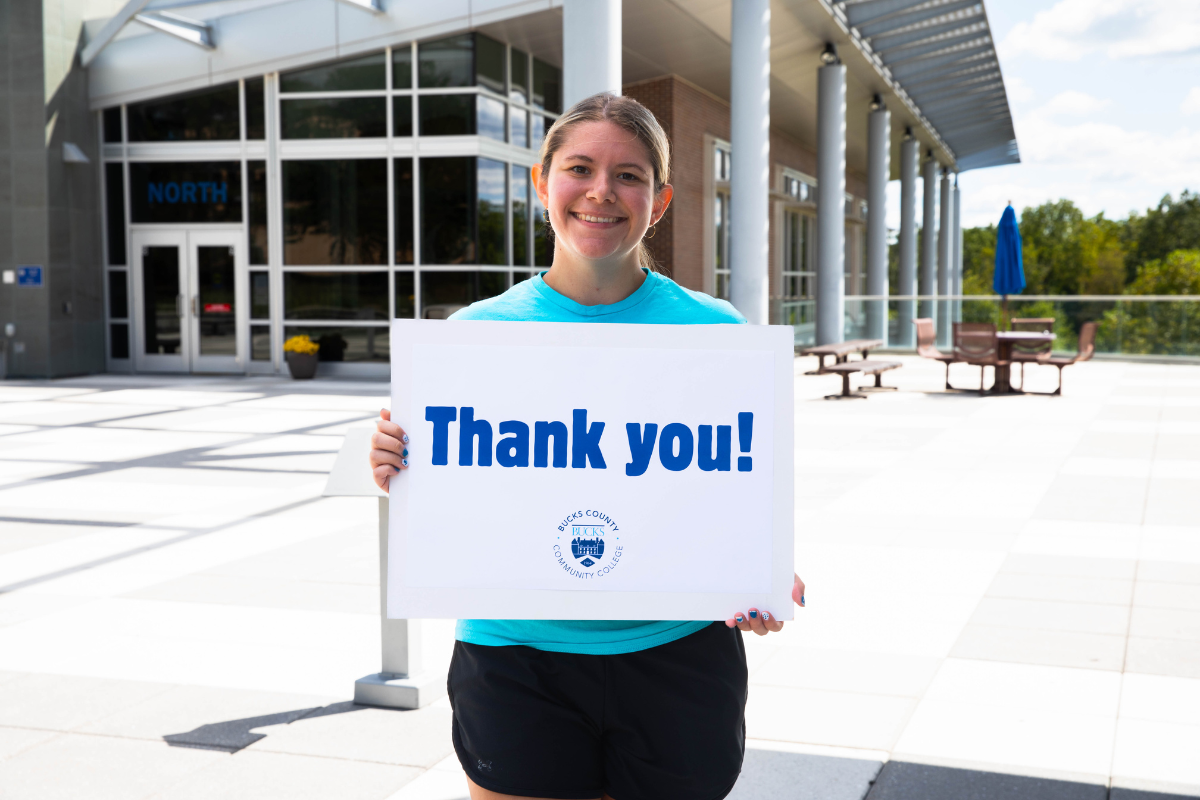 Student holding a thank you sign