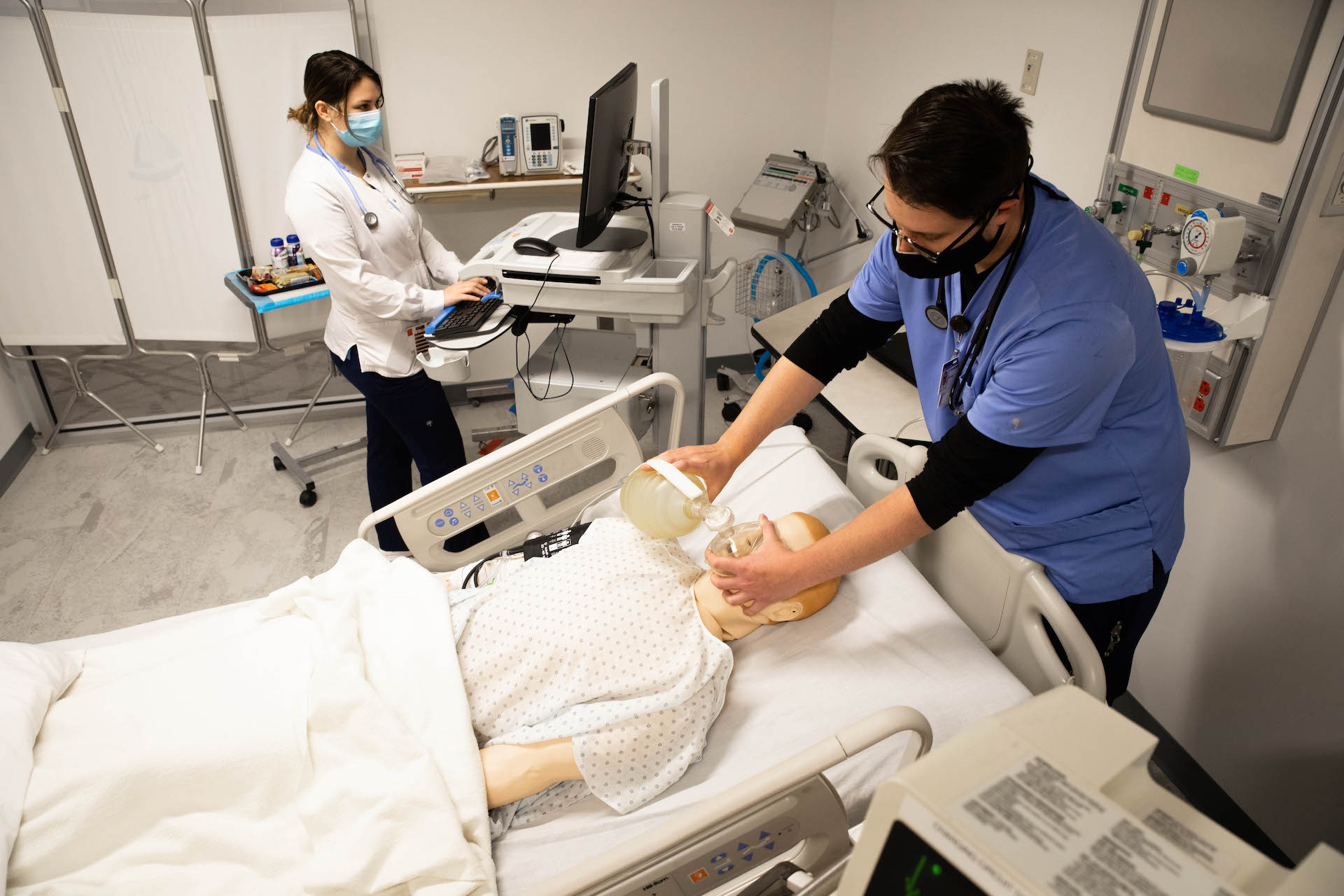 two people administering CPR to dummy