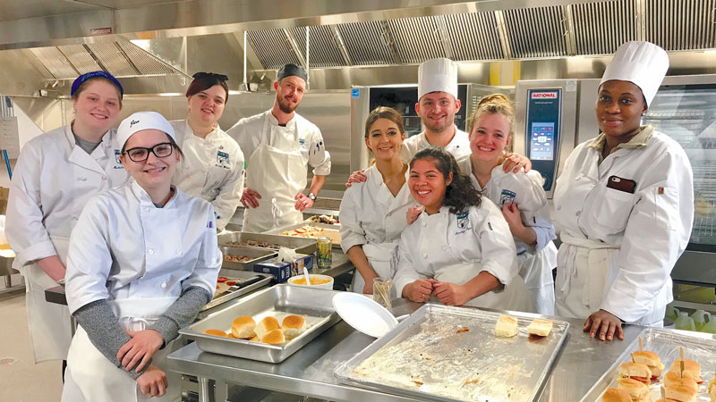 Group of culinary students gathered in kitchen