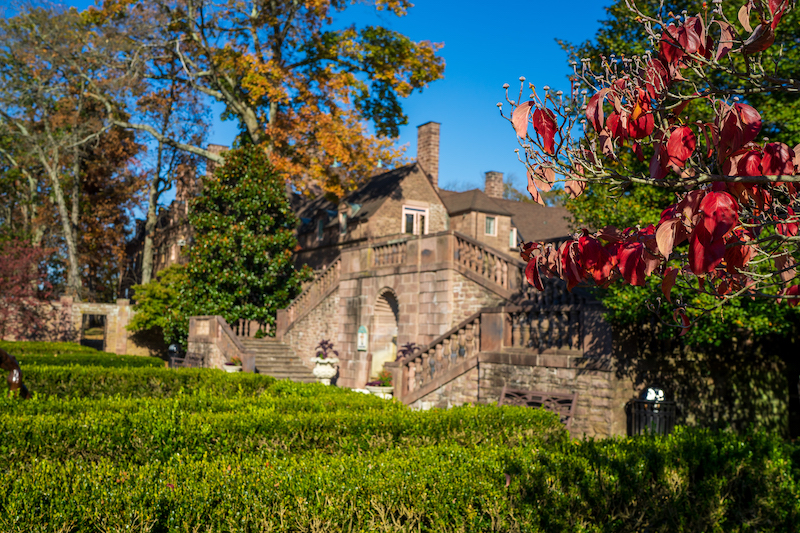 tyler hall in the distance from the gardens with red leaves in the foreground