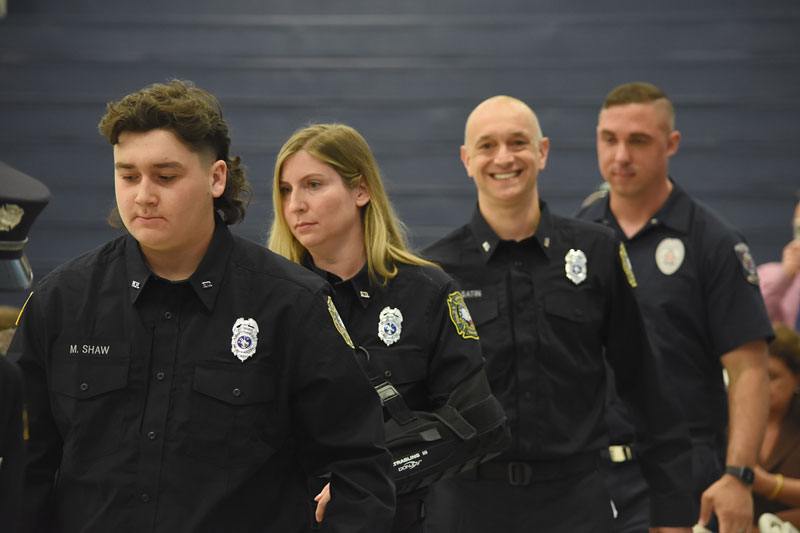 Volunteer firefighters (left-right) Matthew Shaw, Tracy Topolin, Vladimir Usatin and Steven Whiskeyman process into the Newtown Campus Gymnasium