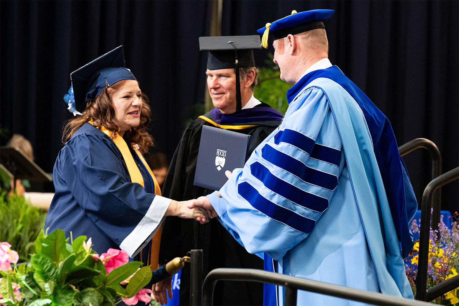 Female graduate receiving diploma on stage