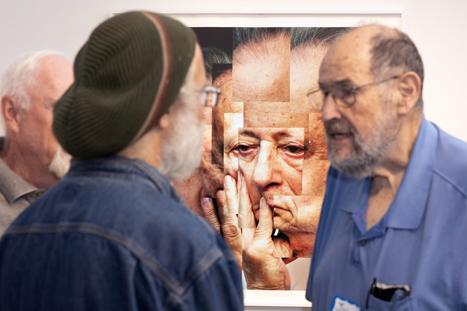 Male gallery visitors talking with painting in background