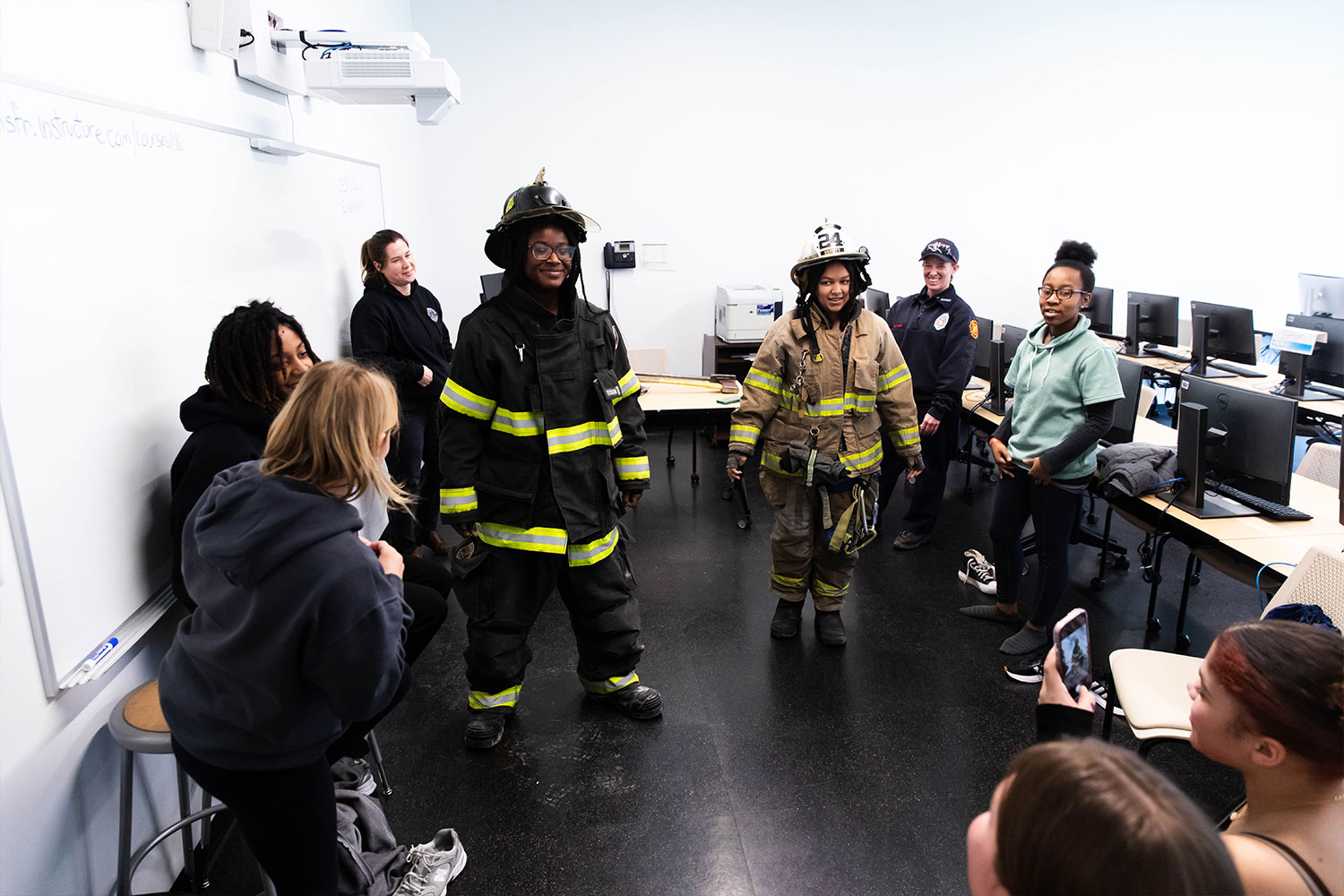 Young females trying on firefighter gear