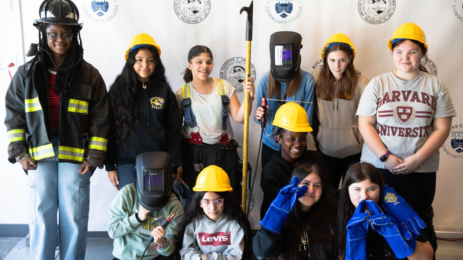 Female middle school students representing various building and construction trades as well as emergency responders pose for a group photo during ‘Girls Ignite'