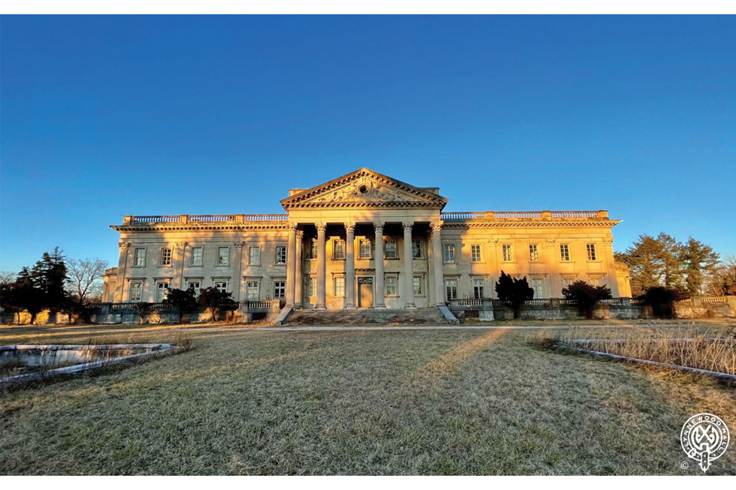 The historic Lynnewood Hall mansion with columns and pediment under a blue sky.