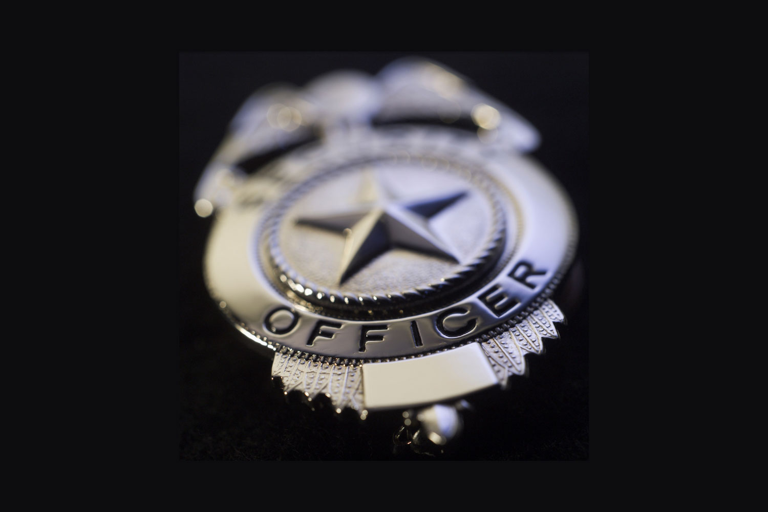 Blurred police badge with word officer in focus