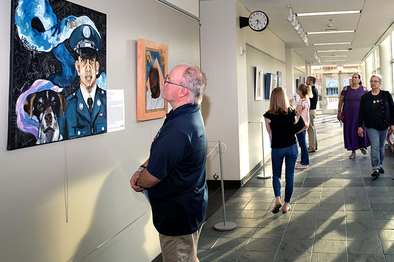 A visitor to the Gallery at Lower Bucks reads the story of a veteran who lost his life to gun violence.