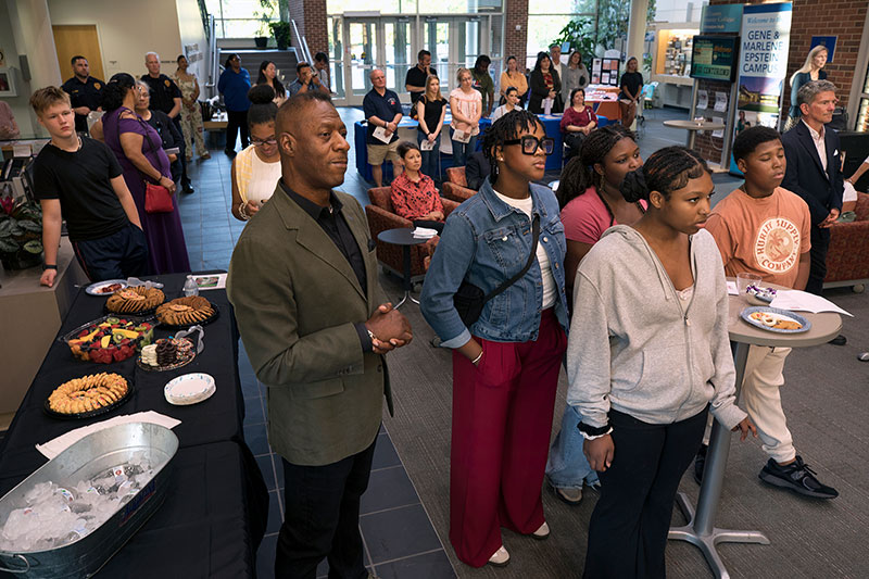 Walter Mims (foreground), executive director of Neighborhood First, awaits his turn to speak at the opening reception for the “Souls Shot Portrait Project”