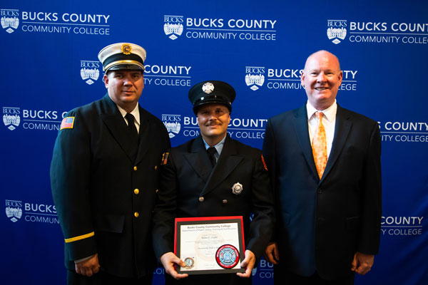 Three people posing with award