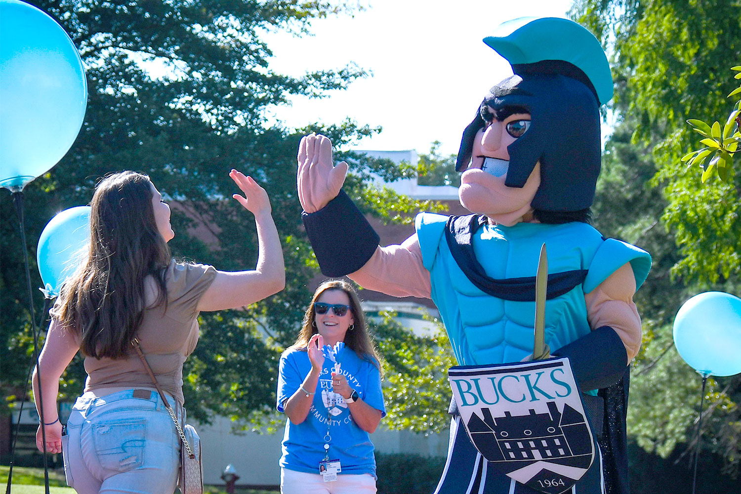 Female student giving a high five to mascot, Brutus