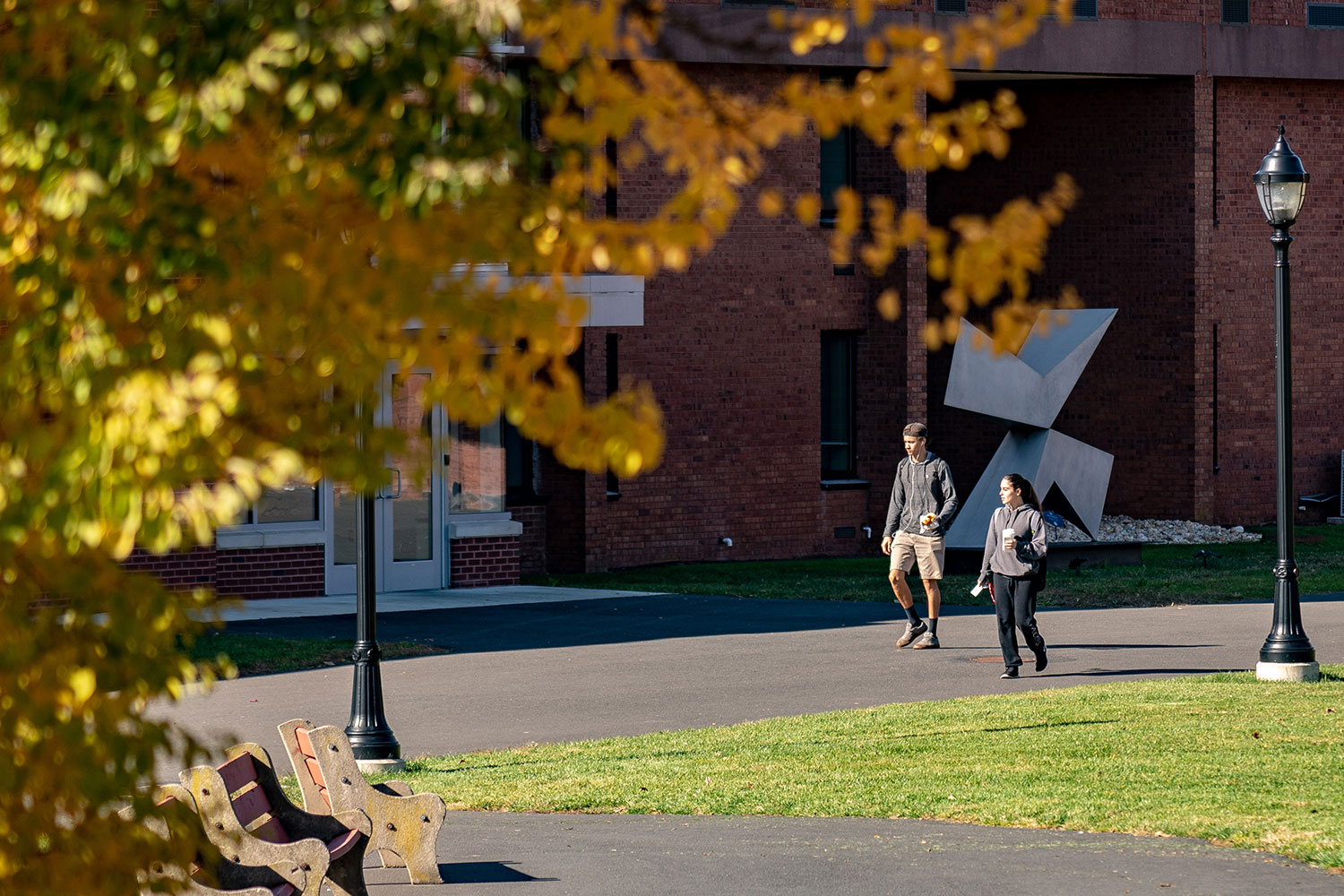 Two students in the distance walking through campus in fall